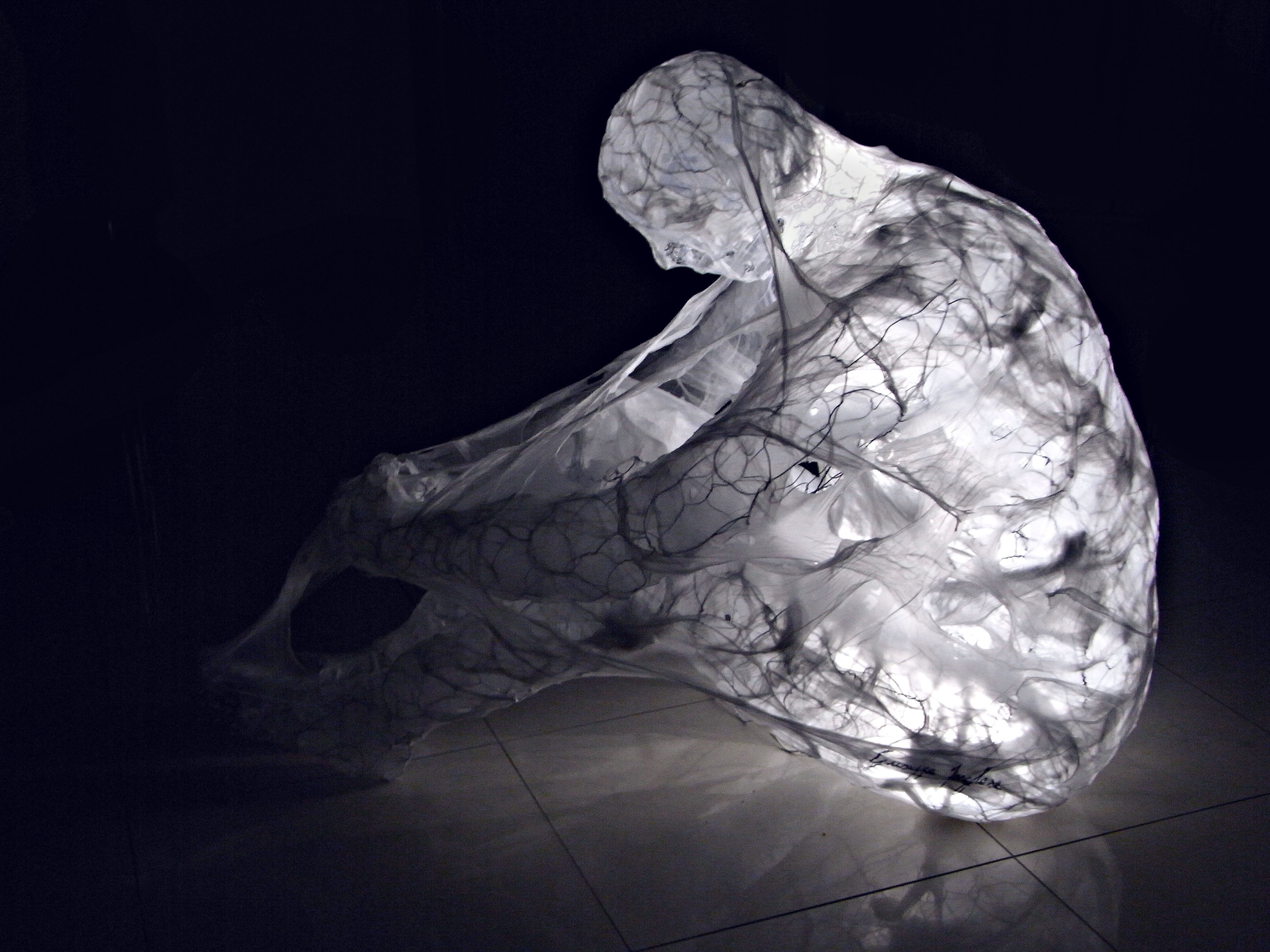 "Metamorfosi - Figura maschile seduta" Woven stainless steel and plastic sculpture with LED lights, cm 99 x 74 x 56, 2014 Unique Piece